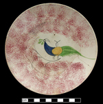 Saucer in sponged and painted peafowl pattern.